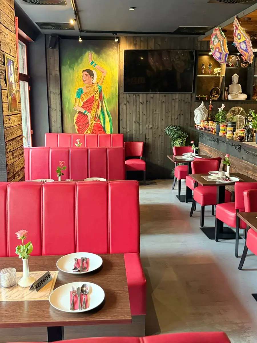 Rote Sitzbänke und farbenfrohe Wandkunst im Restaurant